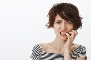 close up worried guilty cute woman grimacing nervously 1